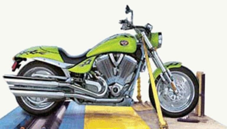 A green motorcycle is parked on a yellow platform.