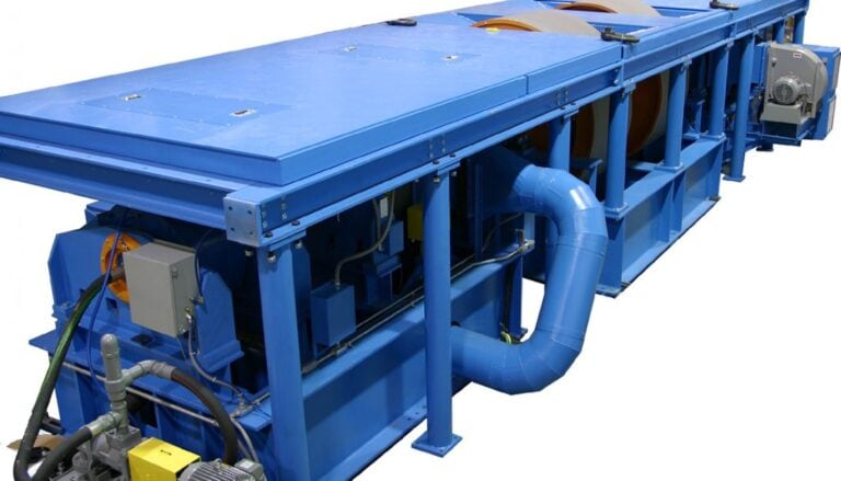 A blue machine with a conveyor belt attached to it.