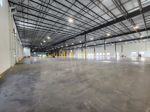 An empty warehouse with concrete floors and lights.