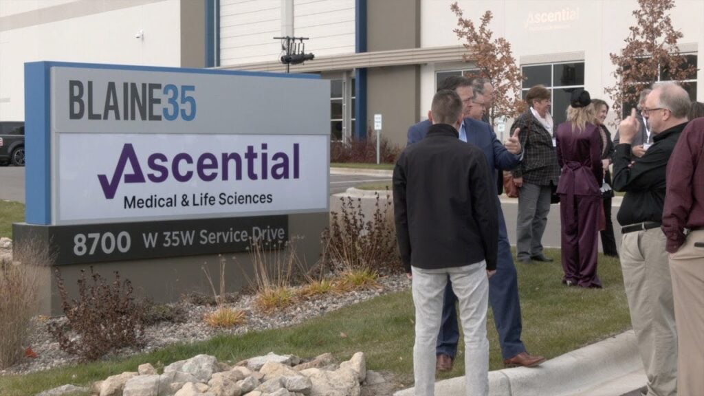 A group of people standing in front of a building that says essential.